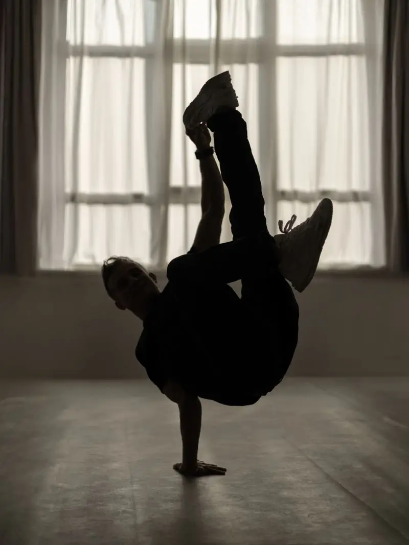 Breakdancer en équilibre sur une main, en contre-jour